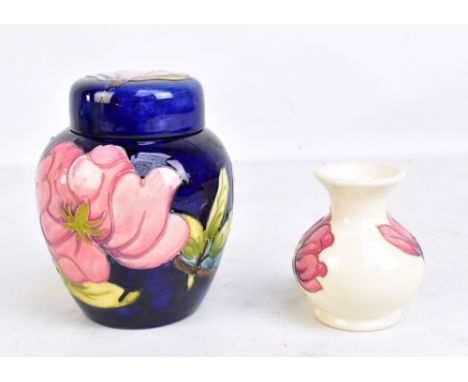 MOORCROFT; a tubeline decorated 'Magnolia' pattern lidded ginger jar on navy ground, height 15cm, and a smaller baluster vase