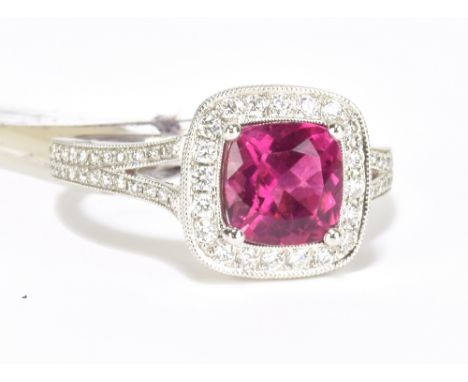 An 18ct white gold diamond and rubellite ring with pierced shoulders and raised platforms, size N, approx 5.1g.