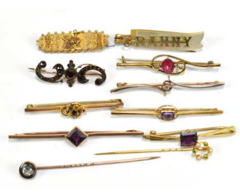 A group of eleven gold and yellow metal brooches and stick pins.