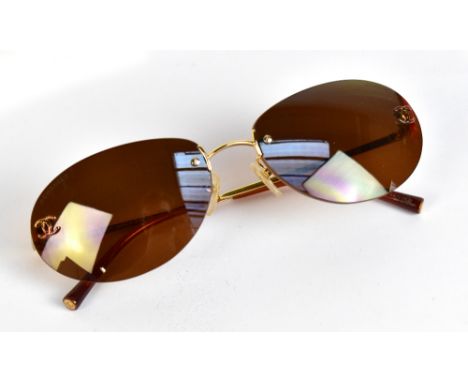 CHANEL; a pair of rimless tinted sunglasses with gold-tone nose and bars with Chanel logo to lenses, in original sunglasses c