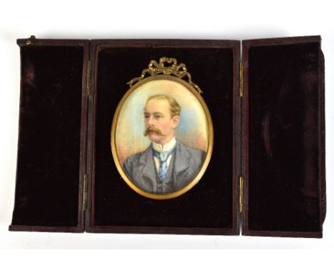 A late 19th/early 20th century watercolour on ivory portrait miniature depicting gentleman with moustache in blue dress coat,