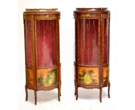 A pair of reproduction French vitrines each with gilt metal detail surrounding a single glazed door decorated with figures in