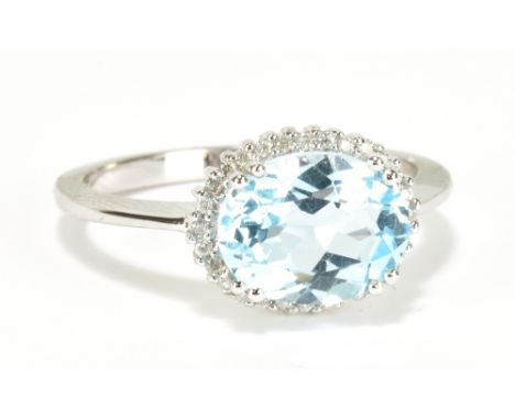A 9ct white gold aquamarine and diamond ring, the oval aquamarine weighing approx 3cts within a border of diamonds weighing a