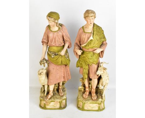 ROYAL DUX; a large pair of figures modelled as a young gentleman beside a goat and young woman beside a sheep, both with pink