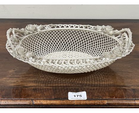 A Belleek oval basket, first period (1865-1899); the three-strand basket of twin handled form, applied with roses and other f