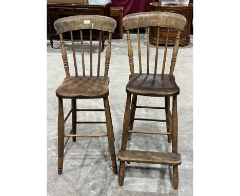 A pair of Victorian beechwood and elm high chairs with stick backs. One lacking foot rest.