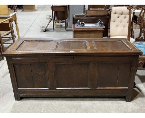 An early 18th Century joined oak chest, the three panel fielded lid over conforming front, raised on channel moulded stiles. 