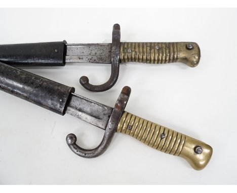 A French 1866 Chassepot sword bayonet with ribbed brass grip, forward curved quillion and painted steel scabbard, dated 1874 