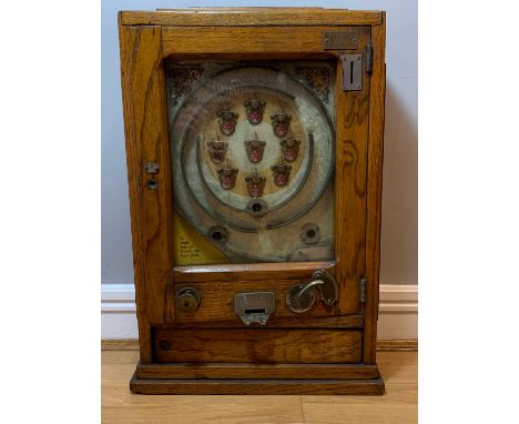 An Allwin penny slot arcade machine, wall mount, with gilt decoration, oak case with glazed hinged door, 40cm x 65cm x 17cm P