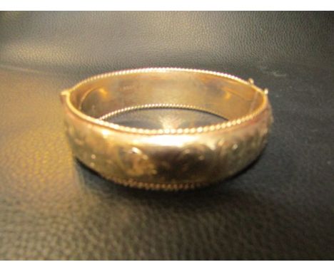 A gold bangle marked 375 9ct 26.8 grams