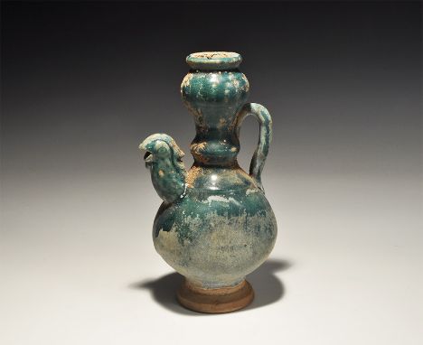 An undated archaistic green-glazed ceramic jug with tall balustered neck, strap handle, spout formed as a bird's head. 593 gr