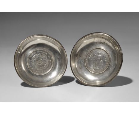 20th century AD. Two small circular silver trinket bowls, the base of the first set with a British Trade Dollar coin (minted 