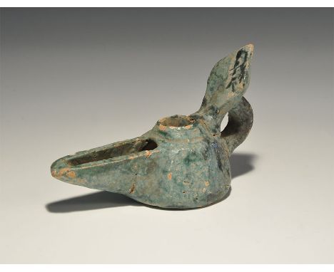 12th century AD. A green-glazed oil lamp with loop handle supporting a lozengiform reflector. 161 grams, 13.5cm (5 1/4"). Pri