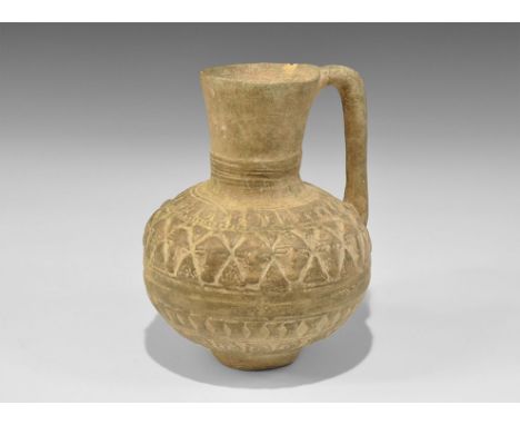 12th-14th century AD. A vessel comprising a bulbous jug with funicular neck and strap handle to the rear, bands of low-relief