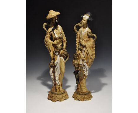 20th century AD. A pair of composition figurines comprising: a bearded male with open-fronted robe and broad hat, holding a b