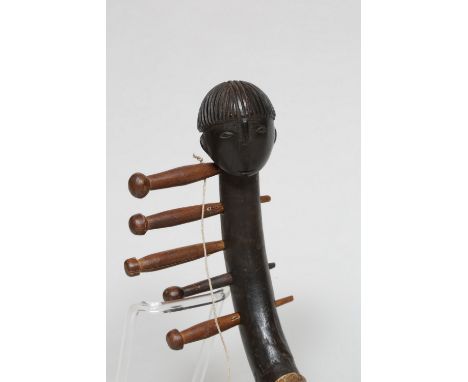DR. Congo, Zande, five stringed harp, with a vellum over the soundboard, the neck topped by a human head.  L. 67 cm. [1]