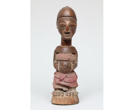 DR. Congo, Songye, standing male power figure, with red cotton strips over torso and legs. With remnants of offering and in t