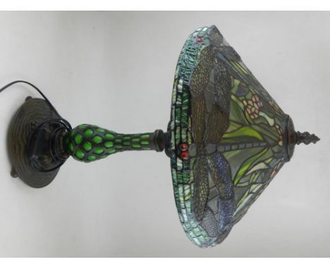 A Tiffany style lamp, having leaded coloured glass shade, raised on a naturalistic metal and green glass base. H:56cm