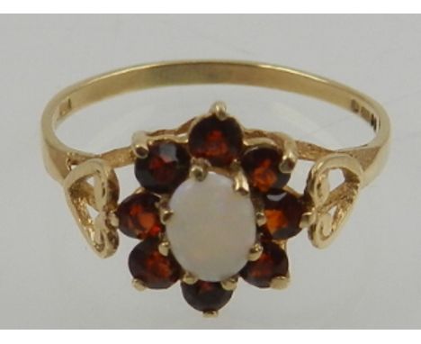 A 9 carat yellow gold, garnet, and opal cluster ring