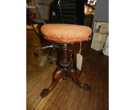 A Victorian rosewood revolving piano stool, raised on tripod legs.