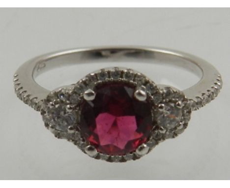 A silver, cubic zirconia and created ruby cocktail ring. 