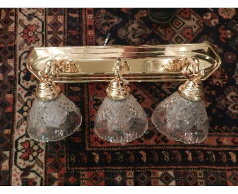 Three branch brass wall light, having glass shade with cross hatched and floral design, L.62cm,