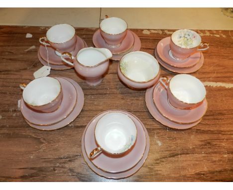 A Aynsley porcelain tea service, having gilt edge and decorated with flowers on pink ground
