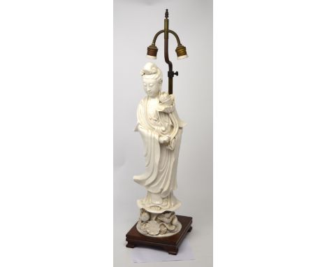 A large Chinese blanc de Chine standing Guanyin figure raised on a naturalistic lotus form base, later adapted to incorporate