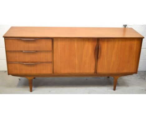 A c1960s G-Plan teak sideboard, two cupboard doors and single interior shelf, three drawers to left with moulded integrated h