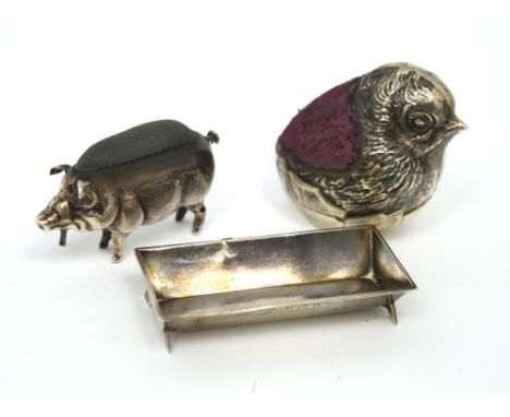 An Edwardian hallmarked silver pig pin cushion and trough, London 1903 and a hallmarked silver chick pin cushion modelled as 