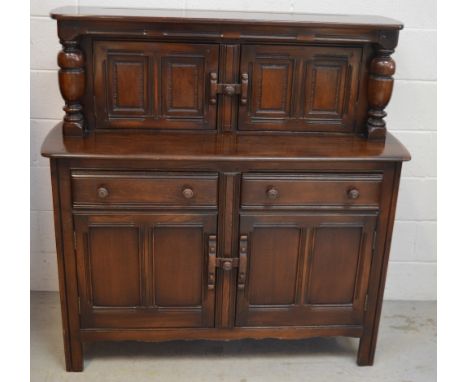 An Ercol oak country-style buffet sideboard, two cupboard doors to top with turned pillar supports to either side above two d