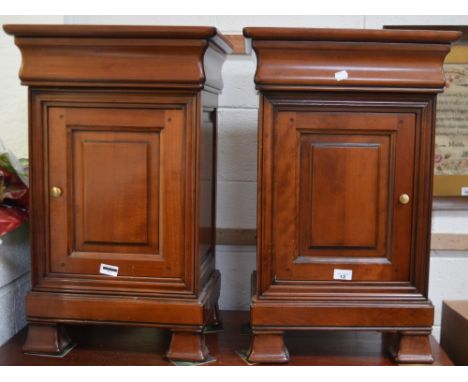 A pair of Bridget Forester mahogany bedside cabinets, moulded top over over moulded door, on shaped bracket feet (2).   CONDI