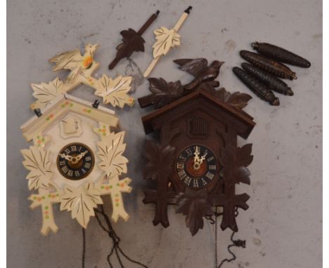 A Black Forest style cuckoo clock with cone weights and a white-painted cuckoo clock (2).