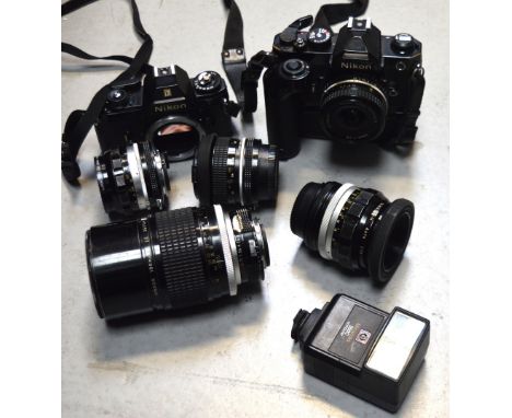 A Nikon EM film camera body and a further Nikon camera with Nikon Series E 28mm 1:2.8 lens and three further Nikon lenses to 