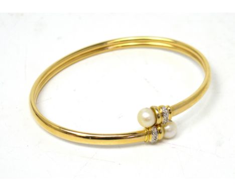 A 14ct gold bangle set with diamonds capped with cultured pearls, approx 6.2g.