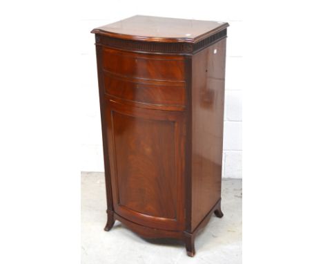 An early 20th century mahogany bow-front gramophone cabinet on reeded supports, lift-up lid with record deck (lacking inner w