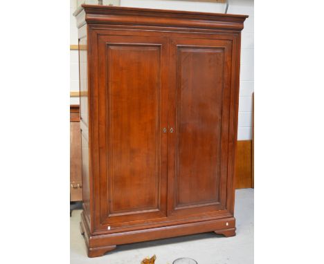 A Simon Horn mahogany twin-door wardrobe with moulded panels to doors and sides, on shaped bracket feet, 200 x 134cm.   CONDI