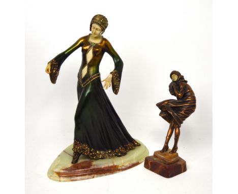 An Art Deco style figure of a lady in evening gown on onyx plinth, a further bronzed figure of a lady in a coat battling agai