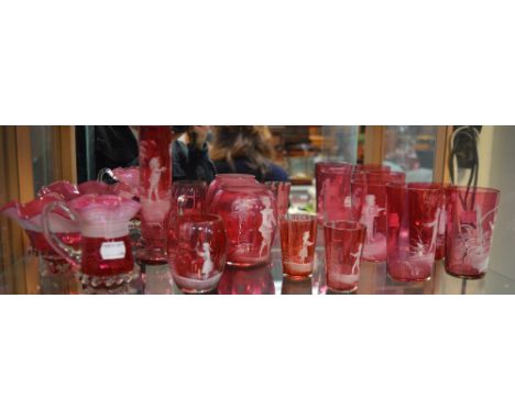 Nine pieces of cranberry glass, each decorated in the style of Mary Gregory in white enamel and a further jug and bowl with e
