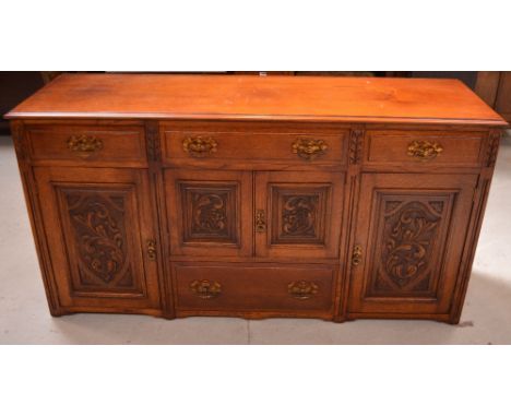 An Art Nouveau style oak sideboard, three drawers above various cupboard sections and single lower drawer, width 165cm.