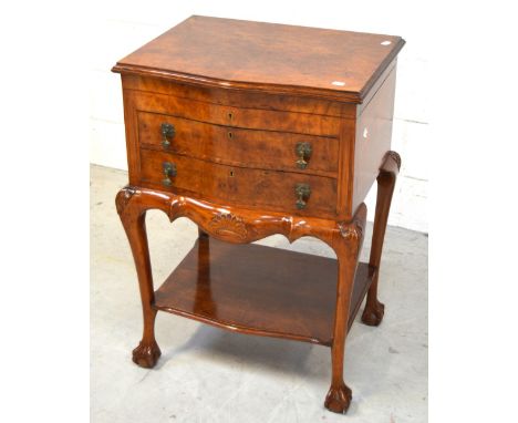 An early 20th century walnut cutlery cabinet, lift-up top above two bow-front drawers containing a twelve-place Liner and Hal