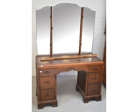 A 20th century oak six-drawer kneehole mirror-back dressing table raised on bracket feet, width 98cm.   CONDITION REPORT  The