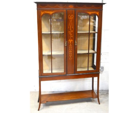 An Edwardian mahogany inlaid display cabinet, ribbon and swag decoration above a central panel of ribbons and flora, glazed d