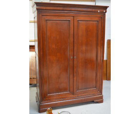 A Simon Horn mahogany twin-door wardrobe with moulded panels to doors and sides, on shaped bracket feet, 200 x 134cm.   CONDI