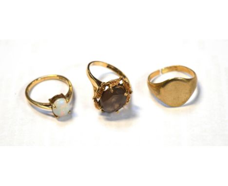 Three 9ct gold rings; one set with oval faceted smoky quartz, one with opal and a plain signet ring (af), approx combined 10.