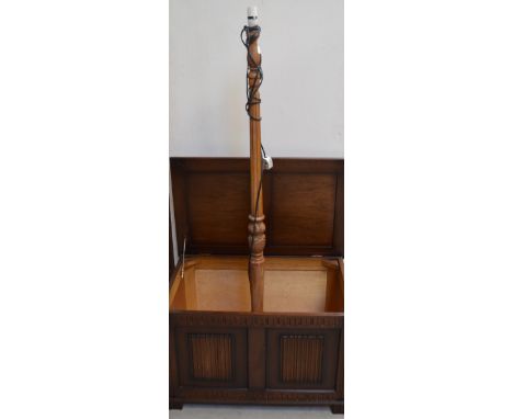 An oak blanket box of simple form, width 78cm and an oak standard lamp on carved circular support, height approx 145cm.(2).