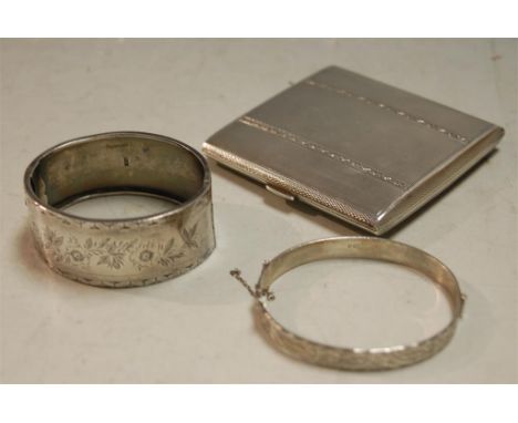 A mid-20th century silver pocket cigarette case, having all-over engine turned decoration; together with a silver bangle; and