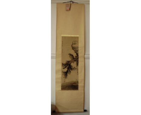 An early 20th century Chinese silk embroidered scroll depicting bird of prey upon a branch, bears signature