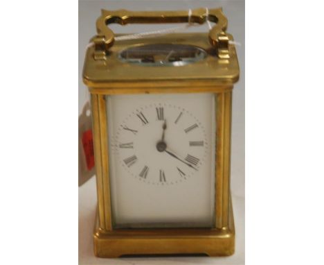 An early 20th century lacquered brass cased carriage clock having white enamel dial with Roman numerals, visible platform lev