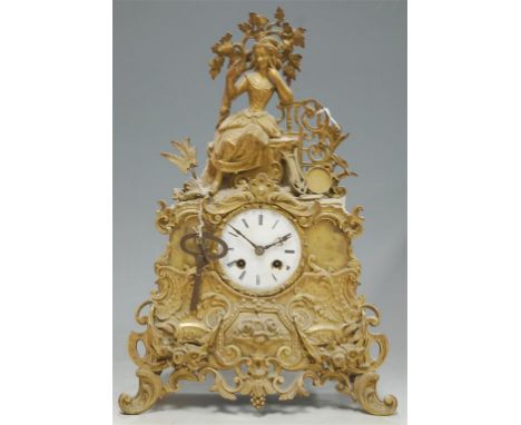 A late 19th century French gilt metal mantel clock having white enamel dial and Roman numerals surmounted by a seated musicia